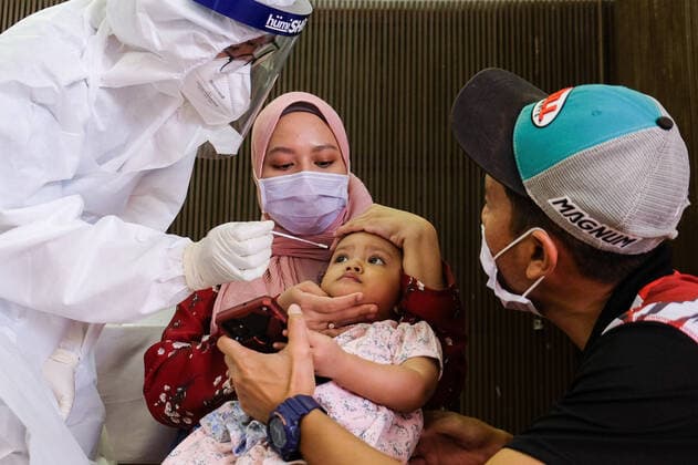 May 26, 2021, Sungai Buloh, Malaysia: A mother holds her child down so as to get the nasal swab sample during the COVID19 testing at a test center in Sungai Buloh..Malaysia has recorded the highest daily cases of Covid-19, yesterday with a record of 7,289 cases. Selangor government continues to conduct mass COVID19 screening tests over the state to battle the coronavirus pandemic. Sungai Buloh Malaysia - ZUMAs197 20210526_zaa_s197_021 Copyright: xFarisxHadziqx
