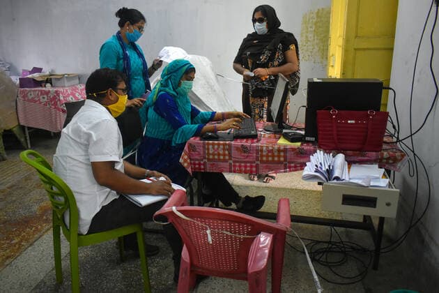 India: Covid-19 vaccination in Kolkata Health workers checking the identity of a woman before giving the Covishield (Covid-19 vaccine) inside a West Bengal state Health Vaccination centre in Kolkata. Kolkata West Bengal India Copyright: SudiptaxDas