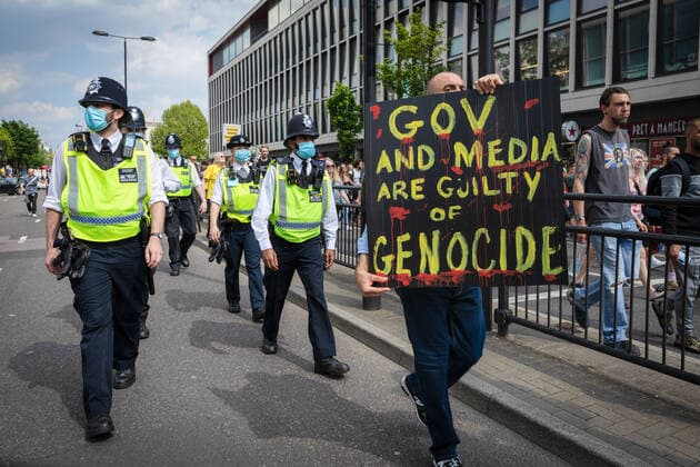 May 29, 2021, London, United Kingdom: A protester holding a placard marches past police officers during an anti-lockdown protest..Thousands of people came out under the banner to Unite for Peace and their Human Rights. The number of people attending the protests has increased month on month since the introduction of the COVID-19 restrictions. London United Kingdom - ZUMAs197 20210529_zaa_s197_058 Copyright: xAndyxBartonx