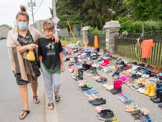 May 30, 2021, KAHNAWAKE, PQ, Canada: Lynn Karonhia-Beauvais and grandson Jamieson Kane put down tobacco as a tribute to all the victims of the residential school system as they walk next to children s shoes outside St. Francis Xavier Church in Kahnawake, Quebec, Sunday, May 30, 2021. The remains of 215 children have been found buried at the site of a former residential school in Kamloops, B.C. KAHNAWAKE Canada  - ZUMAc35_ 20210530_zaf_c35_001 Copyright: xGrahamxHughesx