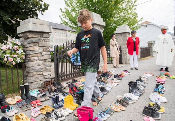 May 30, 2021, KAHNAWAKE, PQ, Canada: Jamieson Kane puts down tobacco as a tribute to all the victims of the residential school system as he walks amongst children s shoes outside St. Francis Xavier Church in Kahnawake, Quebec, Sunday, May 30, 2021. The remains of 215 children have been found buried at the site of a former residential school in Kamloops, B.C. KAHNAWAKE Canada  - ZUMAc35_ 20210530_zaf_c35_007 Copyright: xGrahamxHughesx