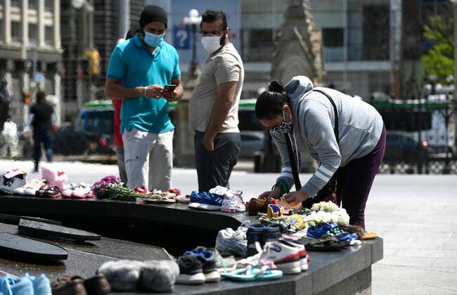 May 30, 2021, Ottawa, on, Canada: Shoes are placed at the Centennial Flame on Parliament Hill in Ottawa in memory of the 215 children whose remains were found at the grounds of the former Kamloops Indian Residential School at TkÃ¢â‚¬â ¢emlups te Secwo pemc First Nation in Kamloops, B.C., on Sunday, May 30, 2021, Ottawa Canada  - ZUMAc35_ 20210530_zaf_c35_042 Copyright: xJustinxTangx