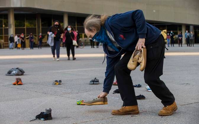 (210531) -- TORONTO, May 31, 2021 -- A man puts shoes on the ground as he takes part in a memorial event for the 215 children whose remains have been found buried at a former Kamloops residential school in Toronto, Canada, May 30, 2021. The reported discovery of the remains of 215 indigenous children at a former residential school in Kamloops in western Canada has shocked Canadian people. (Photo by Xinhua) CANADA-TORONTO-KAMLOOPS INDIGENOUS SCHOOL-CHILDREN REMAINS-MEMORIAL ZouxZheng 
