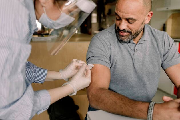 Mature man looking at female healthcare worker injecting medicine Sweden, Stockholm, model released, property released Copyright: xMaskotx , MA86523