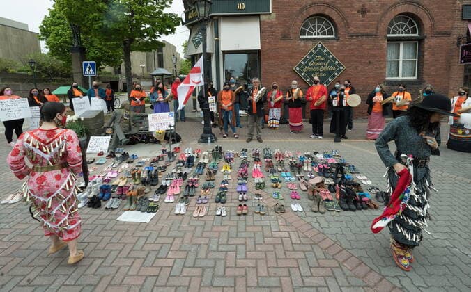 May 31, 2021, CHARLOTTETOWN, PE, Canada: Two Indigenous dancers perform around the 215 pairs of children s shoes placed next to a Sir John A. MacDonald statue in Charlottetown on Monday, May 31, 2021 during a ceremony for the 215 children found at the Kamloops Indian Residential School. CHARLOTTETOWN Canada  - ZUMAc35_ 20210531_zaf_c35_019 Copyright: xJohnxMorrisx