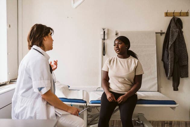 IMAGO Creative: Brustkrebsmonat Female medical expert discussing with patient sitting on examination table at medical clinic Sweden, Stockholm, model released, property released Copyright: xMaskotx , MA86712