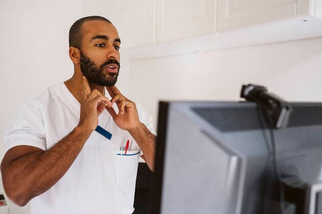 IMAGO Creative: Lokalhelden - Gesundheits- und Rettungskräfte Male doctor consulting through video call at medical clinic Sweden, Stockholm, model released, property released Copyright: xMaskotx , MA86753