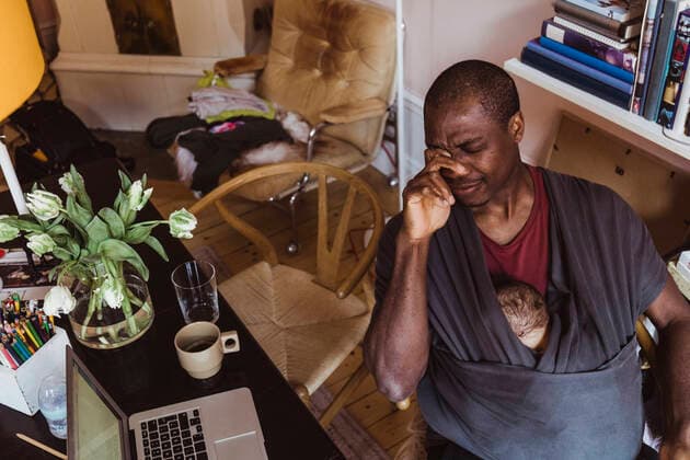 IMAGO Creative: Gesundheit, Burnout Tired father with baby boy in carrier sitting at home office Sweden, Stockholm, model released, property released Copyright: xMaskotx , MA86842