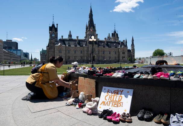 May 31, 2021, Ottawa, on, Canada: An indigenous kneels in front of sweetgrass as shoes sit on the Eternal flame in recognition of discovery of children s remains at the site of a former residential school in Kamloops, B.C., on parliament hill in Ottawa on Monday May 31, 2021. Ottawa Canada  - ZUMAc35_ 20210531_zaf_c35_046 Copyright: xAdrianxWyldx