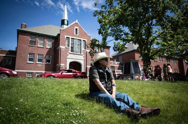 May 31, 2021, Kamloops, BC, Canada: Kamloops Indian Residential School survivor Clayton Peters, 64, who was forced into the school for 10 years, sits on the lawn at the former school, in Kamloops, B.C., on Monday, May 31, 2021. Peters parents and his brothers were also forced into the facility. The remains of 215 children have been discovered buried near the former school. Kamloops Canada - ZUMAc35_ 20210531_zaf_c35_073 Copyright: xDarrylxDyckx