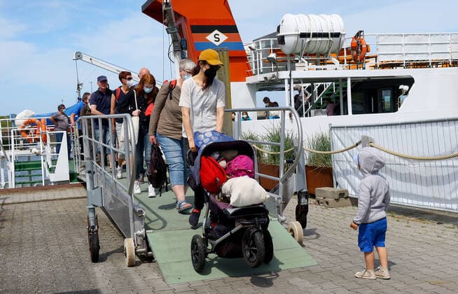 Holidaymakers and day trippers leave the passenger ship Spiekeroog II in the harbour of Neuharlingersiel,state-approved North Sea health resort at the North Sea,municipality in Lower Saxony in the
