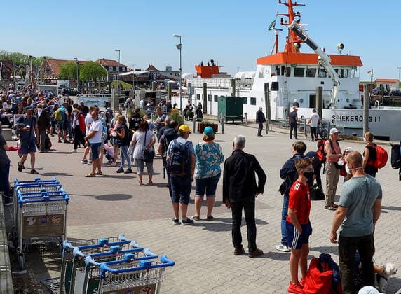 Holidaymakers and day trippers wait to board the passenger ship Spiekeroog II in the harbour of Neuharlingersiel,state-approved North Sea health resort at the North Sea,munic