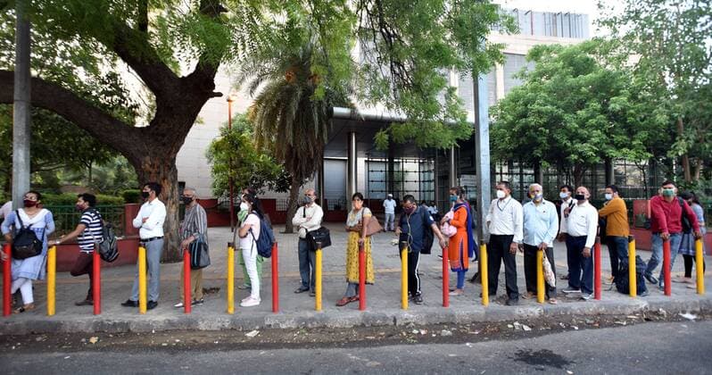 NEW DELHI, INDIA - JUNE 1: People standing with social distancing waiting for DTC bus at a bus stand at ISBT on June 1, 2021 in New Delhi, India. As due to Covid relaxations Metro services are yet not opened and DTC buses operating at 50% occupancy, daily commuters are facing problem. (Photo by Sonu Mehta Hindustan Times) Bus Passengers Face Difficulty In Delhi Due To Covid Restrictions