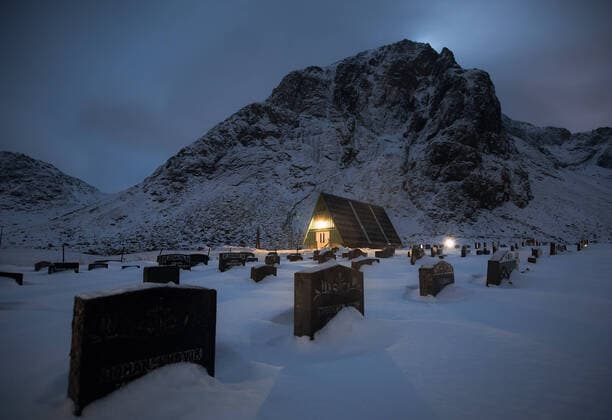View of a graveyard at dusk in the Lofoten Islands with the church in the background Copyright: xPacoxFarerox Model Released