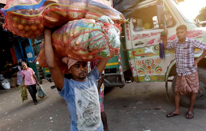 Coronavirus Emergency In Kolkata A migrant labours carry vegetable sack on his head from a wholesale vegetable market in Kolkata, India, 02 June, 2021. India is preparing a stimulus package for sectors worst affected by a deadly coronavirus wave, aiming to support an economy struggling with a slew of localized lockdowns, people familiar with the matter said. The finance ministry is working on proposals to bolster the tourism, aviation and hospitality industries, along with small and medium-sized companies according to an Indian media report. Kolkata West Bengal India aditya-notitle210602_npnJI  Copyright: xIndranilxAdityax