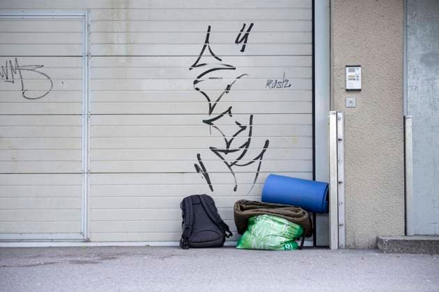 Obdachlosigkeit in Österreich *** Homelessness in Austria In Österreich haben Obdachlose Personen die Möglichkeit, im Winter in Notschlafstellen zu nächtigen. Aufgrund der Coronakrise wurde in Wien das sogenannte ,,Winterpaket bis August 2021 verlängert. Bild: Vor einem Garagentor in der Nähe einer Notschlafstelle ist ein Schlafsack abgestellt. Salzburg, Österreich. 21 Mai 2021 *** Austria offers homeless people emergency shelters for sleeping especially in the winter time. Due to corona virus crisis the emergency shelters were extended till August 2021. Picture: A sleeping bag in front of a garage door next to an emergency shelter. Salzburg, Austria. May 21st, 2021 