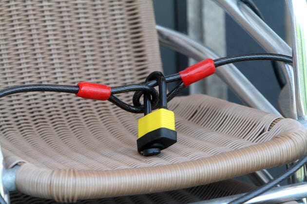 A steel padlock secures the chairs of a closed restaurant in downtown Würzburg, Bavaria, Germany