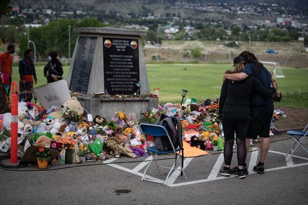 June 4, 2021, Kamloops, BC, Canada: People pause at a monument outside the former Kamloops Indian Residential School where flowers, cards and stuffed animals have been left as part of a growing makeshift memorial to honour the 215 children whose remains have been discovered buried near the facility, in Kamloops, B.C., on Friday, June 4, 2021. Kamloops Canada - ZUMAc35_ 20210604_zaf_c35_089 Copyright: xDarrylxDyckx