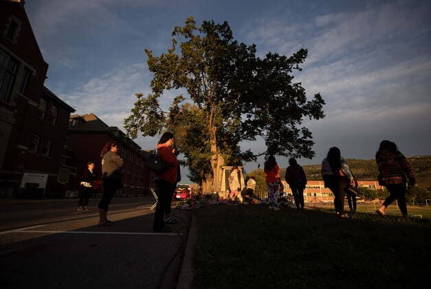 June 4, 2021, Kamloops, BC, Canada: People gather around a makeshift memorial outside the former Kamloops Indian Residential School, honouring the 215 children whose remains have been discovered buried near the facility, in Kamloops, B.C., on Friday, June 4, 2021. Kamloops Canada - ZUMAc35_ 20210604_zaf_c35_162 Copyright: xDarrylxDyckx
