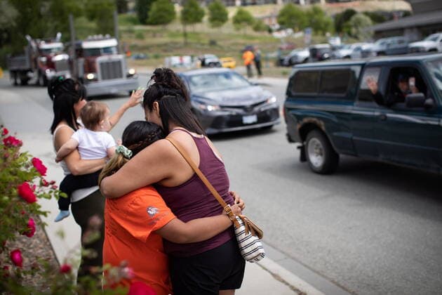 June 5, 2021, Kamloops, BC, Canada: Danielle Hink, of the Yunesit in First Nation, which is part of the Tsilhqot in National Government, hugs her daughter Cyrah John, 9, while watching as a convoy of truckers and other vehicles travel past in support of the Tk emlups te Secwepemc people, after the remains of 215 children were discovered buried near the former Kamloops Indian Residential School, in Kamloops, B.C., on Saturday, June 5, 2021. Kamloops Canada - ZUMAc35_ 20210605_zaf_c35_069 Copyright: xDarrylxDyckx