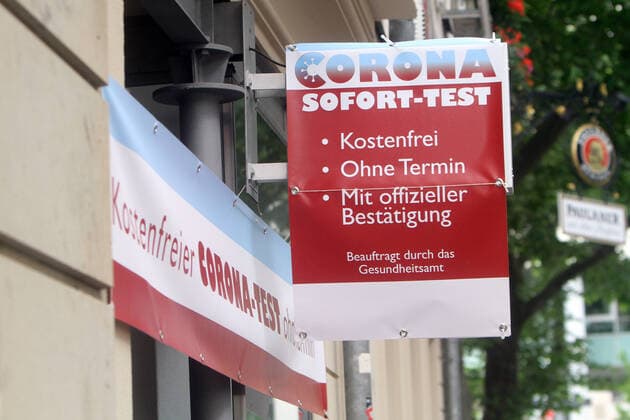 A sign reading Corona Sofort Test kostenlos ohne Termin mit offizieller Bestätigung beauftragt durch das Gesundheitsamt hangs above a test center in downtown Stuttgart, Baden Württemberg, Germany