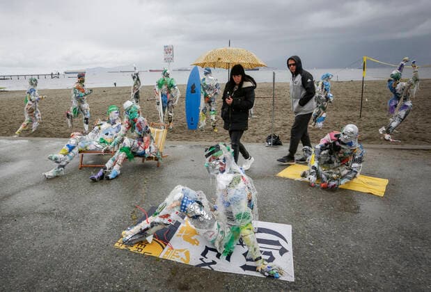 (210606) -- VANCOUVER, June 6, 2021 -- People look at figures made with plastics removed from shorelines at Kitsilano Beach in Vancouver, British Columbia, Canada, on June 6, 2021. Created by multidisciplinary artist Caitlin Doherty and made with plastics removed from Canadian shorelines, a set of figures named plastic beachgoers embody people s collective contribution to plastic pollution, bring the topic of shoreline pollution to the forefront. (Photo by Xinhua) CANADA-VANCOUVER-INSTALLATIONS-PLASTIC BEACHGOERS LiangxSen 