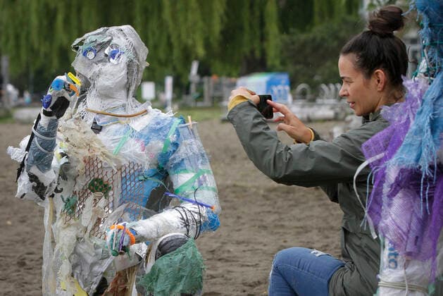 (210606) -- VANCOUVER, June 6, 2021 -- A woman takes photos of a figure made with plastics removed from shorelines at Kitsilano Beach in Vancouver, British Columbia, Canada, on June 6, 2021. Created by multidisciplinary artist Caitlin Doherty and made with plastics removed from Canadian shorelines, a set of figures named plastic beachgoers embody people s collective contribution to plastic pollution, bring the topic of shoreline pollution to the forefront. (Photo by Xinhua) CANADA-VANCOUVER-INSTALLATIONS-PLASTIC BEACHGOERS LiangxSen 