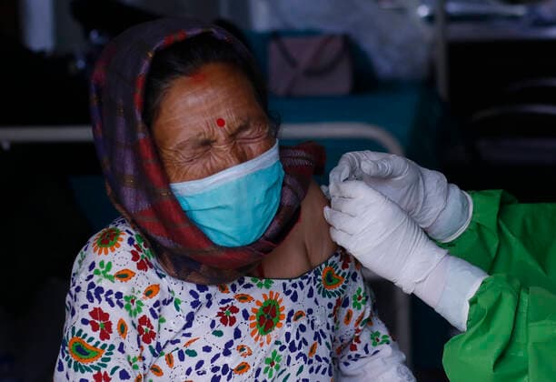 June 8, 2021, Kathmandu, Nepal: A woman reacts as she gets vaccinated against the coronavirus disease (COVID-19) as the government started a campaign to vaccinate for the 60-64 age group after China provided Nepal with one million doses Sinopharm Vero cell COVID-19 vaccine, in Kathmandu, Nepal 08 June 2021. Kathmandu Nepal - ZUMAs242 20210608_zip_s242_001 Copyright: xDipenxShresthax