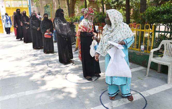 Coronavirus in Indien, landesweite Eindrücke NEW DELHI, INDIA - JUNE 7: People line up to collect food during ration distribution by Delhi Govt at Rajkiya sarvodaya Kanya vidyalaya Asaf ali road, on June 7, 2021 in New Delhi, India. (Photo by Arvind Yadav Hindustan Times) Daily Life Amid Coronavirus Pandemic In India