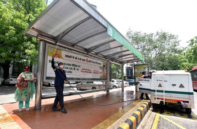 Coronavirus in Indien, landesweite Eindrücke NEW DELHI, INDIA - JUNE 7: A worker sanitizes a DTC Bus stand at Parliament street after unlocking process of COVID-19 lockdown began, on June 7, 2021 in New Delhi, India. (Photo by Sonu Mehta Hindustan Times) Daily Life Amid Coronavirus Pandemic In India