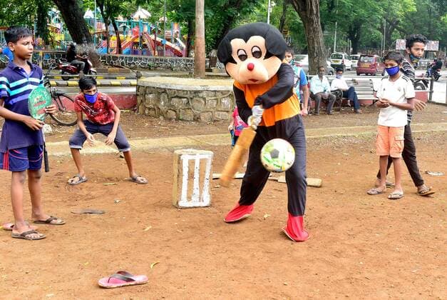 Coronavirus in Indien, landesweite Eindrücke MUMBAI, INDIA - JUNE 7: Social worker Ashok Kurmi dressed as Mickey Mouse plays with children to create awareness of sanitizing their hands regularly and to wear mask while playing at Five Gardens, Wadala, after unlocking of COVID-19 lockdown began in a phased manner from today with playgrounds and public places opened, on June 7, 2021 in Mumbai, India. (Photo by Anshuman Poyrekar Hindustan Times) Maharashtra Lifts Lockdown Restrictions