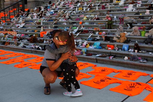 June 8, 2021, Victoria, BC, Canada: Emmy Morris who attended Indian day school and her mother who went to a residential school hugs her daughter Sharon Morris-Jones, 4, from the Tsartlip First Nation as they look at the Orange shirts, shoes, flowers and messages on display on the steps outside the legislature in Victoria, B.C., on Tuesday, June 8, 2021 following a ceremony hosted by the Songhees and Esquimalt First Nations in honour of the 215 residential school children whose remains have been discovered buried near the facility in Kamloops, B.C. Victoria Canada - ZUMAc35_ 20210608_zaf_c35_113 Copyright: xChadxHipolitox