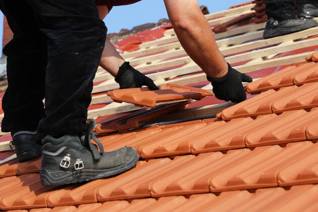 Dachdecker beim Eindecken eines denkmalgeschützten Ziegeldaches *** Roofing contractor covering a listed tiled roof Copyright: xx