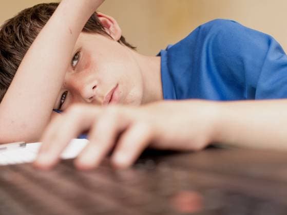 Teenager sitzt alleine lustlos bei den Hausaufgaben *** Teen sits alone listless doing homework 1028901484
