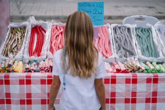 Back view of little girl standing in front of a candy store deciding which sweets to buy, Model released Copyright: xJosexLuisxCarrascosax MR
