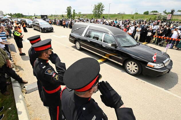 June 12, 2021, London, on, Canada: Police officers salute as hearses pass during the funeral for the four Muslim family members killed in a deadly vehicle attack, in London, Ont., on Saturday, June 12, 2021. Talat Afzaal, 74, her son Salman Afzaal, 46, his wife Madiha Salman, 44, and their 15-year-old daughter Yumna Salman all died last Sunday night while out for a walk after a man in a truck drove them down in what police have called a premeditated attack because they were Muslim. London Canada - ZUMAc35_ 20210612_zaf_c35_069 Copyright: xFrankxGunnx