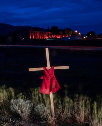 June 13, 2021, Kamloops, BC, Canada: A child s dress is seen on a cross outside the Residential School in Kamloops, B.C., Sunday, June, 13, 2021. The remains of 215 children were discovered buried near the former Kamloops Indian Residential School earlier this month. Kamloops Canada  - ZUMAc35_ 20210613_zaf_c35_091 Copyright: xJonathanxHaywardx