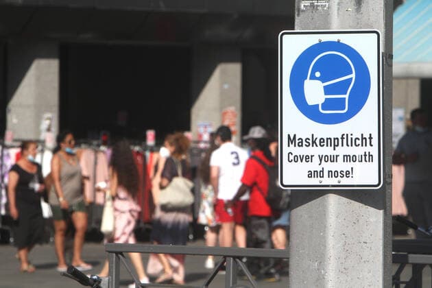 Sign with pictogram and inscription Maskenpflicht hangs on a lamp post at the market place in the city center of Mannheim, Baden Württemberg, Germany