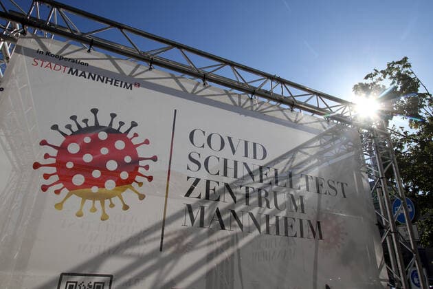 A banner with the inscription Corona Schnelltest Zentrum Mannheim stands on the station square in Mannheim, Baden Württemberg, Germany.