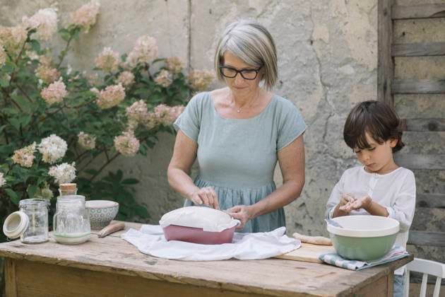 Grandmother preparing bread by grandson playing with dough at back yard model released Symbolfoto property released ALBF01608