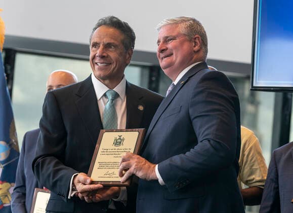 New York: Governor Cuomo Announces COVID-19 Restrictions Lifted Governor Cuomo gives awards of recognition to essential workers at announcement oflifting the COVID-19 restrictions as 70% of adult New Yorkers have received first dose of vaccine at One World Trade Center . Governor praised all New Yorkers for doing their parts during pandemic. Governor especially lauded essential workers and presented awards to those who carried New York State through the COVID-19 pandemic. Governor said that mask requirement for unvaccinated individuals and in certain settings (e.g., large-scale indoor event venues, pre-K to grade 12 schools, public transit, homeless shelters, correctional facilities, nursing homes and health care settings per CDC guidance) Copyright: LevxRadin