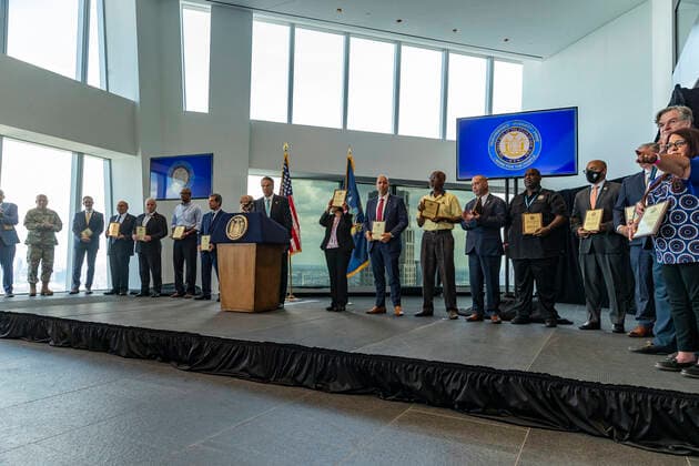 New York: Governor Cuomo Announces COVID-19 Restrictions Lifted Governor Cuomo and awards recipients on stage during his announcement COVID-19 restrictions lifted as 70% of adult New Yorkers have received first dose of vaccine at One World Trade Center. Governor praised all New Yorkers for doing their parts during pandemic. Governor especially lauded essential workers and presented awards to those who carried New York State through the COVID-19 pandemic. Governor said that mask requirement for unvaccinated individuals and in certain settings (e.g., large-scale indoor event venues, pre-K to grade 12 schools, public transit, homeless shelters, correctional facilities, nursing homes and health care settings per CDC guidance) will stay in place Copyright: LevxRadin