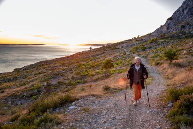 IMAGO Creative: Clickbait, Sport und Fitness IMAGO Creative: Klimawandel - Zukunft und Innovation Senior woman with hiking poles on footpath near Adriatic sea in Omis, Dalmatia, Croatia model released Symbolfoto MAMF01766