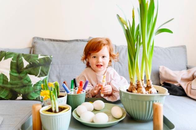 IMAGO Creative: Jahreszeit Frühling, Frühlingsanfang am 20. März Cute redhead girl holding felt tip pen in front of eggs during Easter at home model released Symbolfoto property released VYF00516