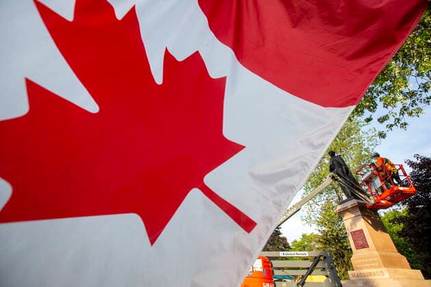 Kanada, Entfernung der Statue von ex-Premierminister John Macdonald in Kingston, Ontario June 18, 2021, Kingston, Ontario, Canada: A Canadian flag can be seen before the removal of the statue of Sir John A. Macdonald in Kingston, Ontario on Friday June 18, 2021. The statue will be removed from a park in his hometown of Kingston while his name will be taken off a local school. Kingston s city council voted this week to take the statue from City Park, place it temporarily in storage, and eventually put it up in Kingston Cataraqui Cemetery where Canada s first prime minister is buried. Kingston Canada - ZUMAc35_ 20210618_zaf_c35_011 Copyright: xLarsxHagbergx