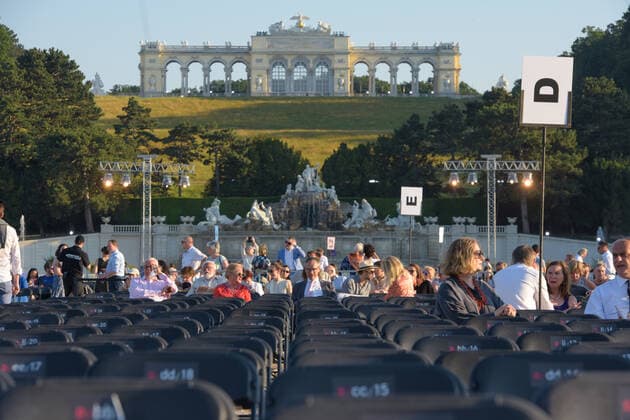 (210619) -- VIENNA, June 19, 2021 -- People wait for the Summer Night Concert to start at the Schoenbrunn Palace in Vienna, Austria, June 18, 2021. The Summer Night Concert 2021 was staged on Friday by the Vienna Philharmonic Orchestra at the Schoenbrunn Palace, a world heritage site in Vienna. About 3,000 spectators are allowed to watch the concert face to face after the COVID-19 restrictions were partially lifted. ) AUSTRIA-VIENNA-SUMMER NIGHT CONCERT GuoxChen 