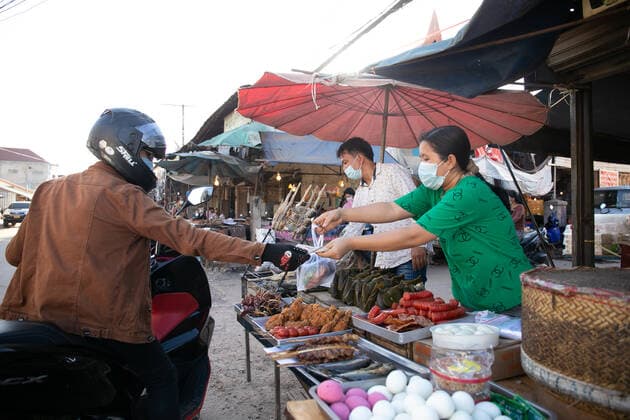 (210620) -- VIENTIANE, June 20, 2021 -- Vendors wearing masks sell take-away food in Vientiane, Laos, June 19, 2021. Laos has extended its lockdown COVID-19 prevention measures across the country for a further 15 days as the community spread of COVID-19 in the capital continues. (Photo by Xinhua) LAOS-VIENTIANE-COVID-19-LOCKDOWN KaikeoxSaiyasane 