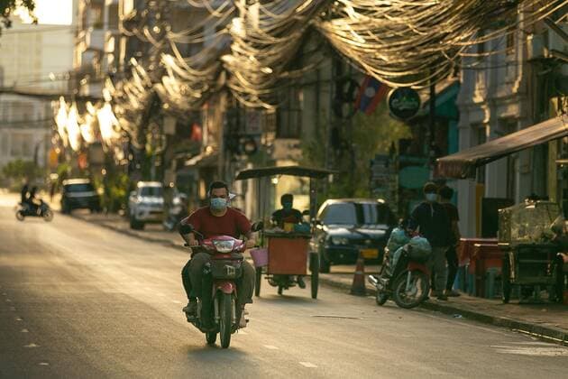 (210620) -- VIENTIANE, June 20, 2021 -- A motorcyclist wearing a face mask rides on a street in Vientiane, Laos, June 19, 2021. Laos has extended its lockdown COVID-19 prevention measures across the country for a further 15 days as the community spread of COVID-19 in the capital continues. (Photo by Xinhua) LAOS-VIENTIANE-COVID-19-LOCKDOWN KaikeoxSaiyasane 