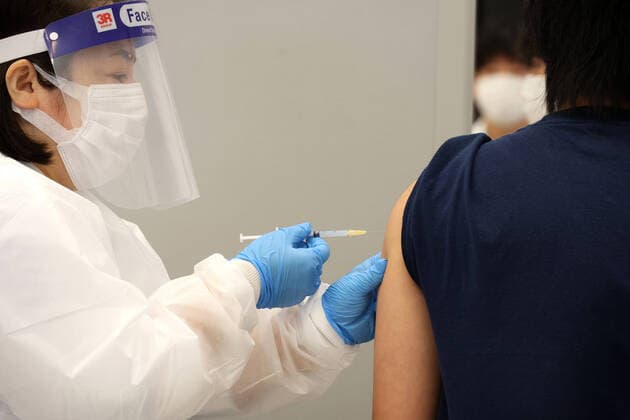 June 21, 2021, Tokyo, Japan - A student of the Nippon Sport Science University receives a dose of COVID-19 vaccine at the university s campus in Tokyo on Monday, June 21, 2021. Japan started mass vaccinations of Moderna s COVID-19 vaccines at workplaces and universities from June 21.  (162940463)