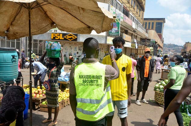(210620) -- KAMPALA, June 20, 2021 -- A security man measures a man s temperature at the entrance of a market in Kampala, Uganda, on June 20, 2021. Ugandan President Yoweri Museveni on Friday announced a string of measures aimed at containing the rapid spread of the novel coronavirus as the country is experiencing a second wave. (Photo by Xinhua) UGANDA-KAMPALA-MARKET-COVID-19-MEASURES NicholasxKajoba 